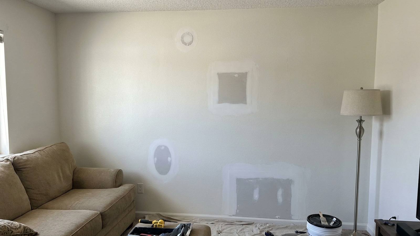 Greenwood living-room wall with four texture-matched drywall patches